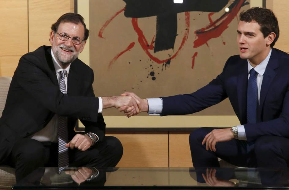 Rajoy estrechando su mano con Rivera