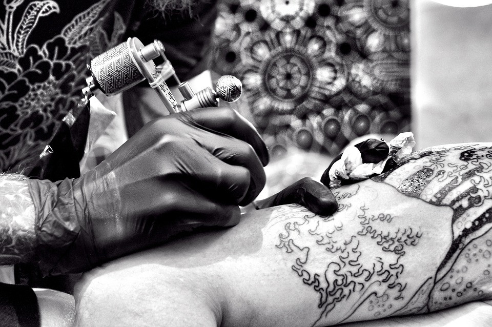Tatuador haciendo tatuaje