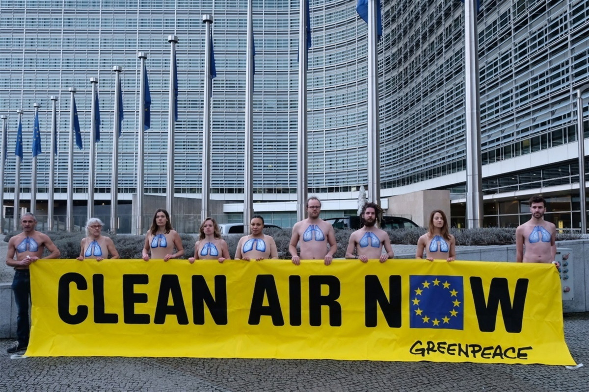 Activistas de Greenpeace despliegan una pancarta en la puerta de la Comisión Europea con el lema 'Aire Limpio Ya'