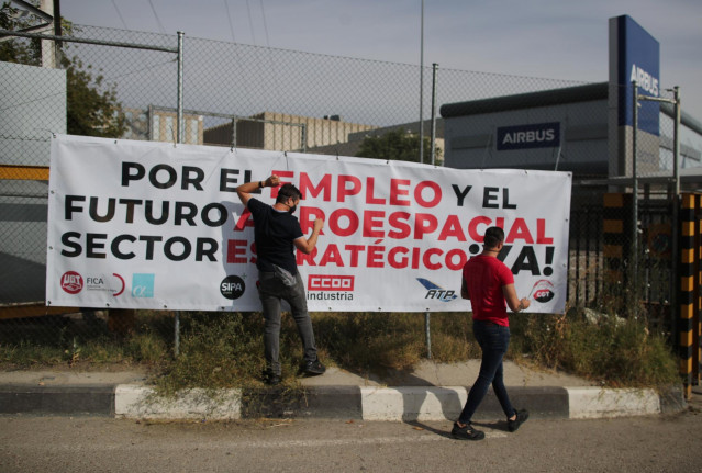 Trabajadores de Airbus colocan una pancarta en la sede del fabricante aeronáutico en protesta de los más de 1.600 despidos que pretende acometer la empresa en España durante los próximos meses