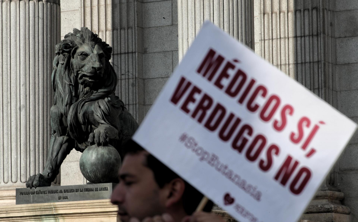 Un hombre de la organización `Derecho a Vivir´ se concentra frente al Congreso de los Diputados con un cartel en el que se lee, `Médicos Sí, Verdugos No´ para protestar en contra de la despenalización de la eutanasia