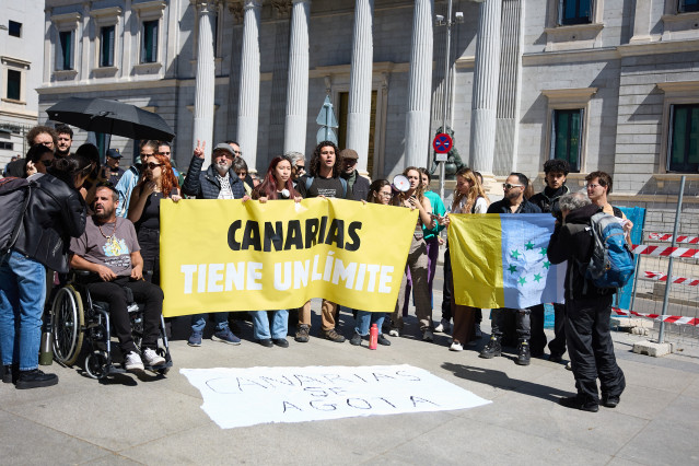 El activista en huelga de hambre, Roberto Mesa (2i), protesta junto a varias personas contra el modelo turístico en Canarias frente al Congreso de los Diputados, a 24 de abril de 2024, en Madrid (España).