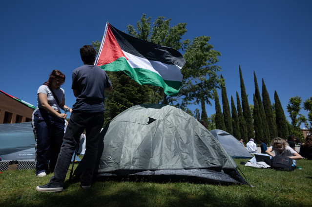 Dos estudiantes con una bandera de Palestina durante una acampada para mostrar su apoyo al pueblo palestino y exigir el fin del conflicto en Gaza