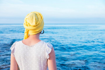 Female with yellow scarf enjoying sea view