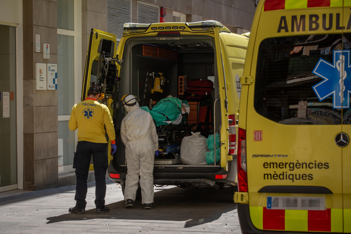 Dos sanitarios en la puerta de una ambulancia en la que hay un paciente contagiado con coronavirus en el Centro de Emergencias de Atención Primaria Pere Camps en el Raval, en Barcelona/Catalunya (Esp