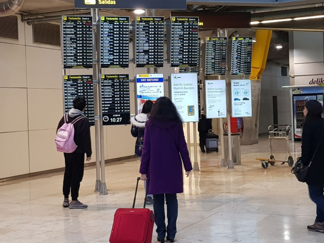 Pasajeros en paneles del aeropuerto de Madrid- Barajas