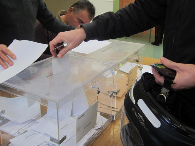 Un joven con casco deposita el voto al Congreso en la urna