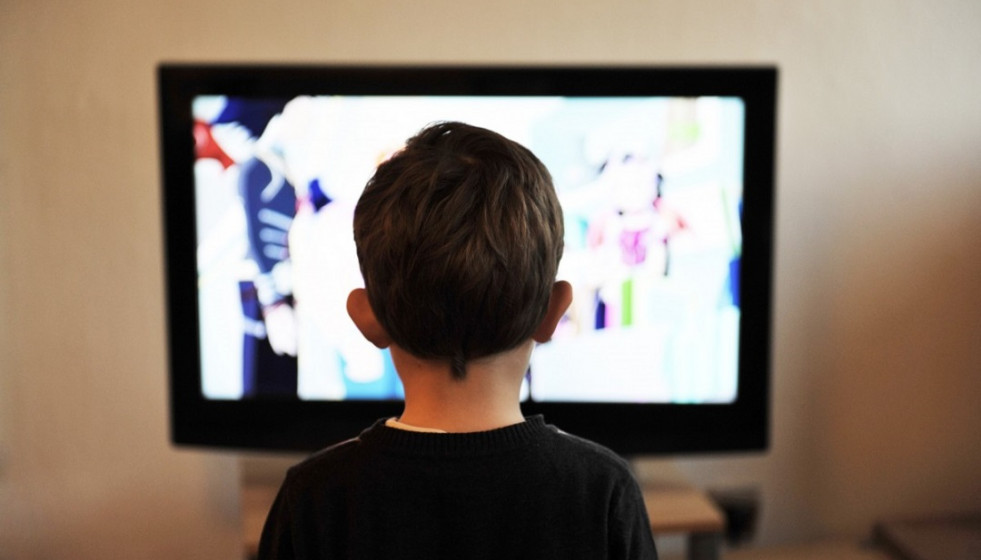 Niño frente a una pantalla de televisión