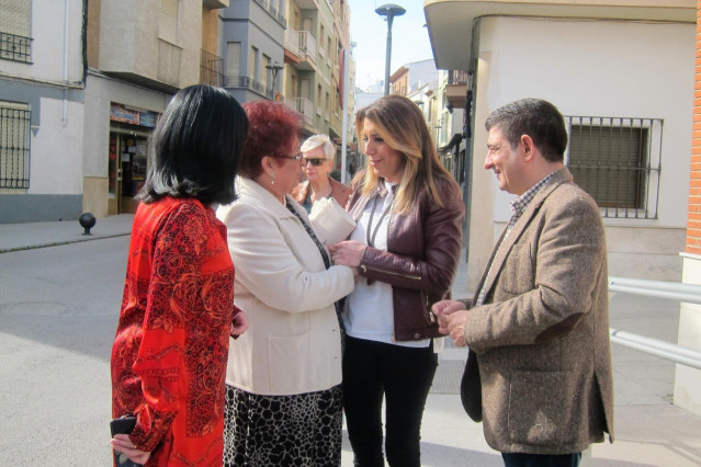 Susana Díaz, junto a Francisca Medina y Francisco Reyes, saluda a una vecina de