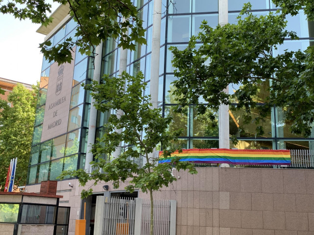Fachada de la Asamblea de Madrid con la bandera LGTBi para conmemorar la celebración del Orgullo en Madrid.