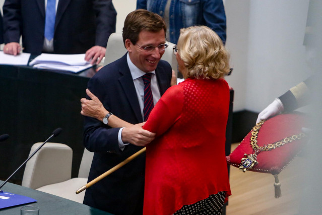 El nuevo alcalde de Madrid, José Luis Martínez-Almeida, se abraza con su predecesora, Manuela Carmena, tras ser investido en la Sesión de constitución del Ayuntamiento de Madrid.