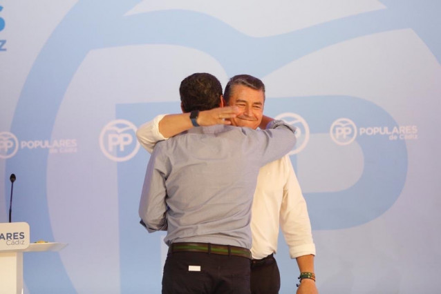 El presidente de la Junta de Andalucía y del PP-A, Juanma Moreno, se abraza con el entonces presidente del PP de Cádiz, Antonio Sanz