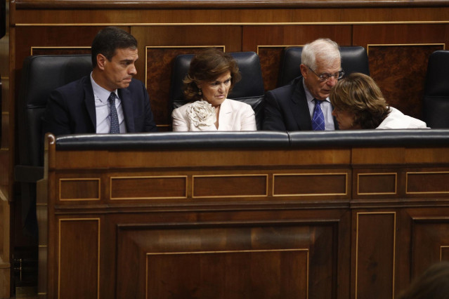 La ministra de Defensa en funciones, Dolores Delgado (1d) habla con el presidente del Gobierno, Pedro Sánchez (1i) durante la segunda sesión del debate de investidura del candidato socialista a la Presidencia del Gobierno.