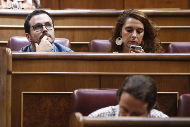El coordinador general de Izquierda Unida, Alberto Garzón, mira al infinito durante el debate previo a la segunda votación para la investidura del del candidato socialista a la Presidencia del Gobierno. A su lado, la portavoz de la Ejecutiva de Podemos, N