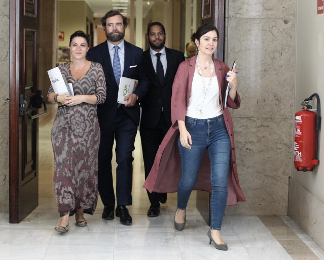 (I-D) Los diputados de Vox Macarena Olona, Iván Espinosa de los Monteros e Ignacio Garriga se dirigen a la Junta de Portavoces del Congreso de los Diputados.