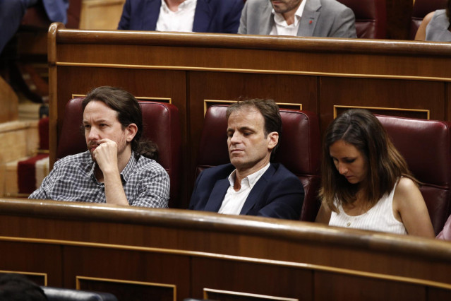 El secretario general de Unidas Podemos, Pablo Iglesias; el portavoz de ECP en el Congreso, Jaume Asens; y la portavoz adjunta de Podemos en el Congreso, Ione Belarra, sentados en sus escaños durante la primera sesión del debate de investidura a la Presid