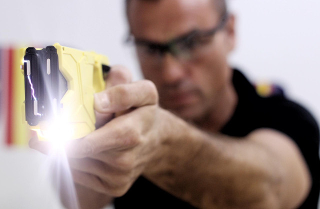 El policía instructor Miguel Berdud hace una demostración del funcionamiento de la pistola eléctrica en la Sede Nacional del Sindicato Unificado de Policía (SUP).