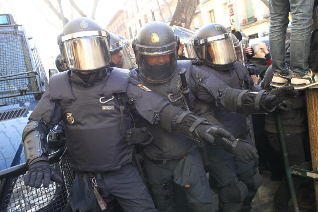 Agentes antidisturbios de la Policía Nacional intentan contener en las inmediaciones de la calle Argumosa de Madrid a los activistas de la plataforma 'Stop Desahucios',  que se manifiestan ante la previsión de varios desahucios decretados para el viernes