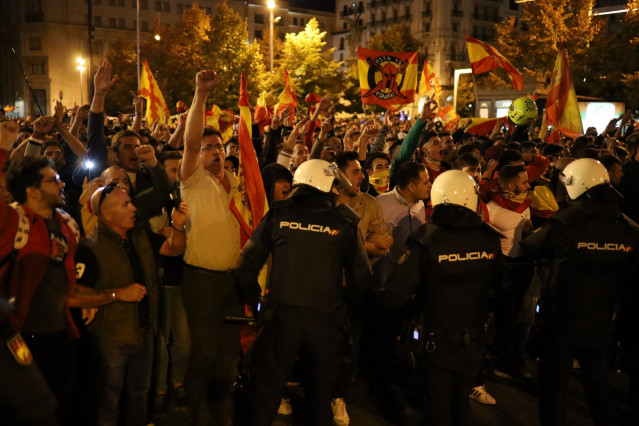 Manifestantes por la unidad de España ondean banderas españolas, mientras agentes de la Policía Nacional controlan que no haya altercados con los CDR Aragón