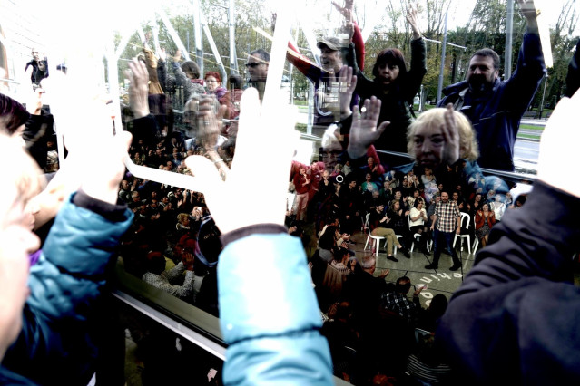 Personas observan y aplauden desde fuera del Palacio Euskalduna a un acto político de Unidas Podemos, en Bilbao (España), a 7 de noviembre de 2019.