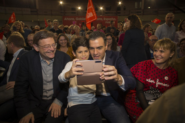 El secretario del PSOE y presidente en funciones del Gobierno, Pedro Sánchez (2d), haciéndose una fotografía con un niño, junto al presidente de la comunidad valenciana, Ximo Puig (3d) y la número uno socialista al congreso por Castellón, Susana Ros (1d),