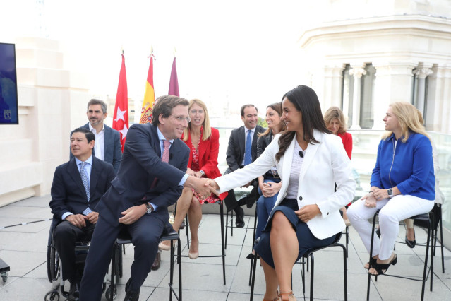 El alcalde de Madrid, José Luis Martínez-Almeida y la vicealcaldesa, Begoña Villacís, acompañados por todos los miembros del equipo de Gobierno municipal, estrechan sus manos durante un acto en el que han hecho balance de los primeros 100 días de gobierno