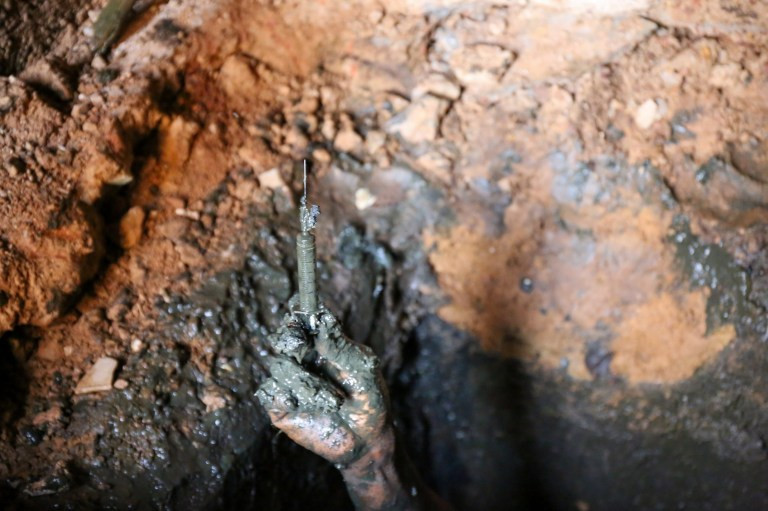 Una mano que muestra una jeringa encontrada dentro de la fosa de la letrina familiar, Uagadugu00fa, Burkina Faso