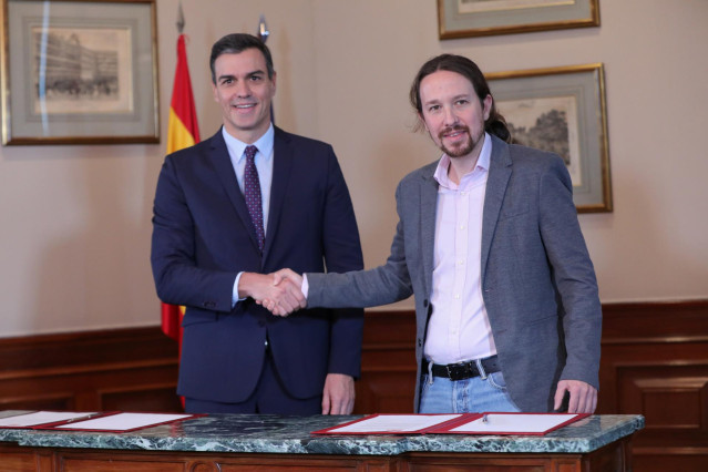 El presidente del Gobierno en funciones, Pedro Sánchez y el líder de Podemos, Pablo Iglesias, se estrechan la mano en el Congreso de los Diputados tras firmar el principio de acuerdo para compartir un gobierno de coalición tras las elecciones generales de
