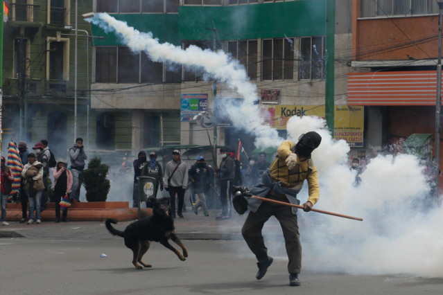 13 November 2019, Bolivia, La Paz: A supporter for the former Bolivian President Morales hurls a tear gas canister back against police during clashes following a mass protests demanding the the resignation of current interim President Jeanine Anez. Photo: