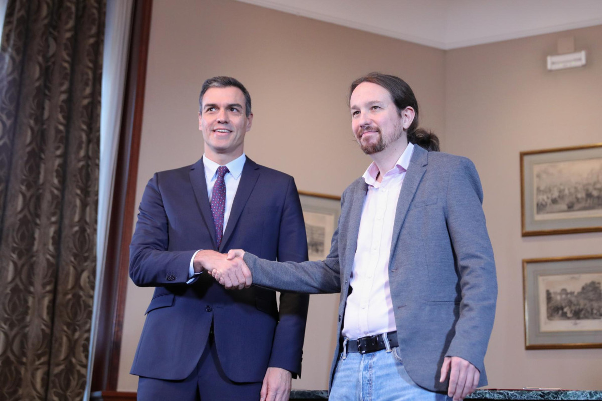 El presidente del Gobierno en funciones, Pedro Sánchez y el líder de Podemos, Pablo Iglesias, se estrechan la mano en el Congreso de los Diputados tras firmar el principio de acuerdo para compartir 