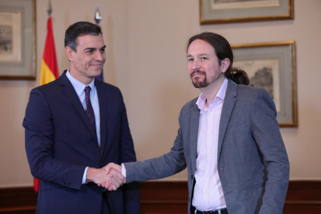 El presidente del Gobierno en funciones, Pedro Sánchez y el líder de Podemos, Pablo Iglesias, se estrechan la mano en el Congreso de los Diputados tras firmar el principio de acuerdo para compartir un gobierno de coalición tras las elecciones generales de