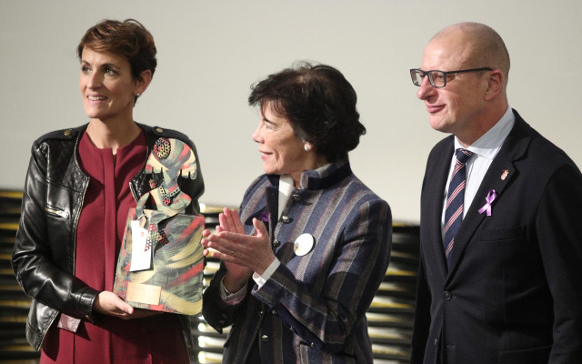 La ministra de Educación y Formación profesional en funciones, Isabel Celaá (c), entrega un premio de reconocimiento por el proyecto SKOLAE a la presidenta de Navarra, María Chivite (i), acompañada del consejero de Educación, Carlos Gimeno.