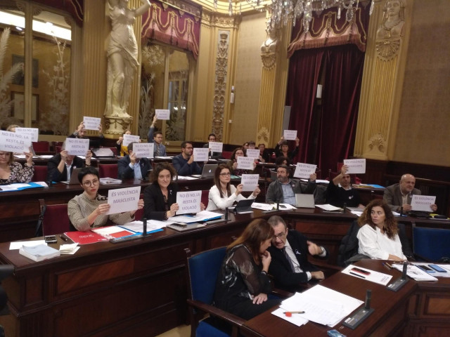 Diputados exhiben carteles en el pleno del Parlament.