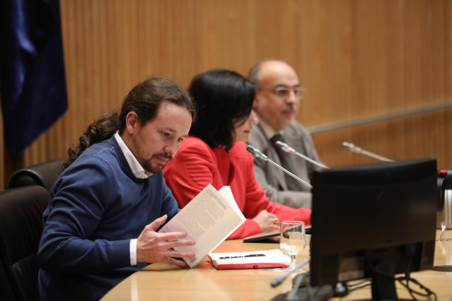(I-D) El secretario general de Podemos, Pablo Iglesias; la periodista Lola García como moderadora y el periodista Enric Juliana durante el diálogo `Nudo España: un año después´ en el Congreso de los Diputados, en Madrid (España), a 5 de diciembre de 2019.