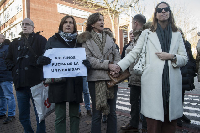 Una mujer sostiene un cartel en el que se lee 
