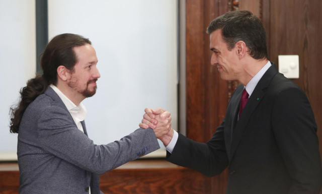 El presidente del Gobierno en funciones, Pedro Sánchez (dech.) y el secretario general de Podemos, Pablo Iglesias (izq), se dan la mano durante el acto de presentación del programa de Gobierno del PSOE y Unidas Podemos, en el Congreso de los Diputados, Ma