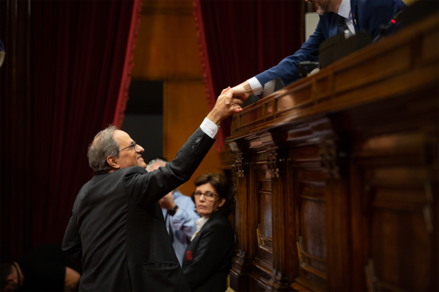 El presidente de la Generalitat de Catalunya, Quim Torra, saluda al presidente de Parlament, Roger Torrent, durante su intervención en una sesión plenaria del Parlament, el 13 de noviembre de 2019.