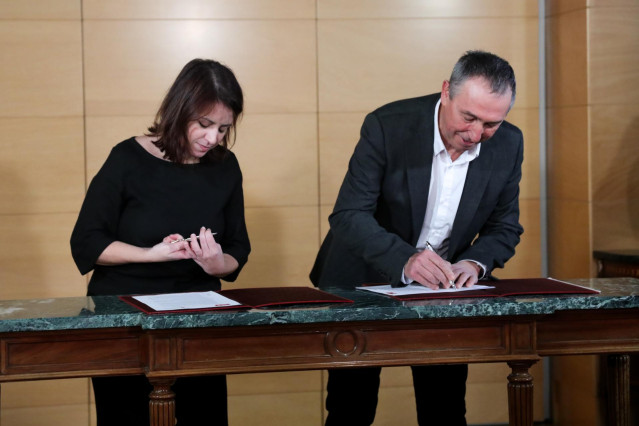 La vicesecretaria general y portavoz del Grupo Socialista en el Congreso, Adriana Lastra; y el portavoz de Compromís en el Congreso de los Diputados, Joan Baldoví, firman el acuerdo  de investidura