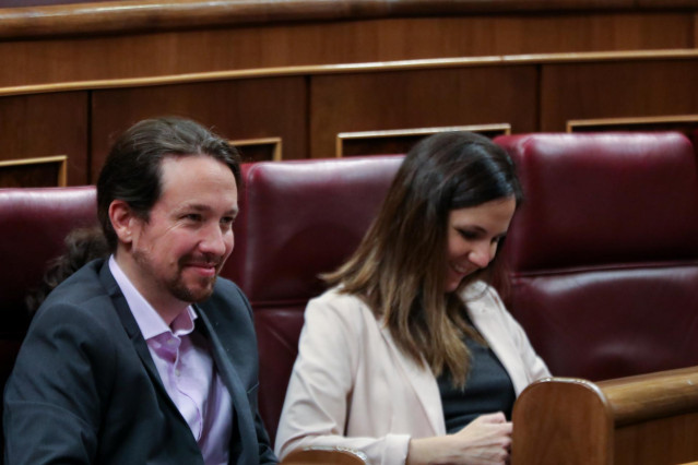 El secretario general de Podemos, Pablo Iglesias, y la portavoz adjunta de Unidas Podemos en el Congreso, Ione Belarra, sonríen en sus escaños durante la primera sesión del debate de investidura del candidato socialista a la Presidencia de Gobierno en la