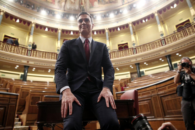 El presidente del Gobierno, Pedro Sánchez, posa sonriente en el hemiciclo del Congreso de los Diputados, tras obtener una votación favorable a su investidura (de 167 a 165 y 18 abstenciones) y convertirse en el presidente electo de la XIV Legislatura, en