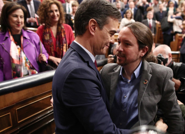 El secretario general de Podemos, Pablo Iglesias, felicita al al presidente del Gobierno, Pedro Sánchez, tras ser elegido al finalizar la segunda sesión de votación para la investidura del candidato socialista a la Presidencia del Gobierno