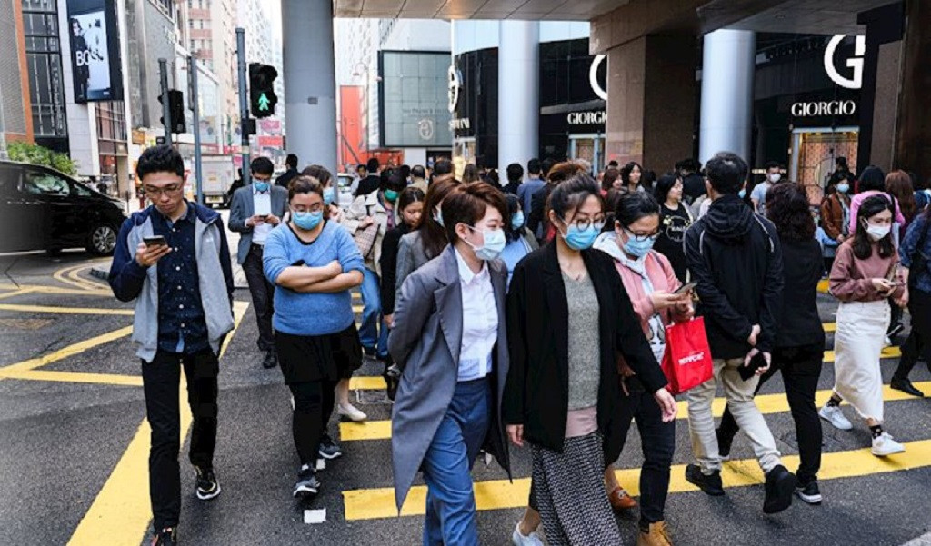 Personas en China caminan con mascarillas por el coronavirus de Wuhan DPA
