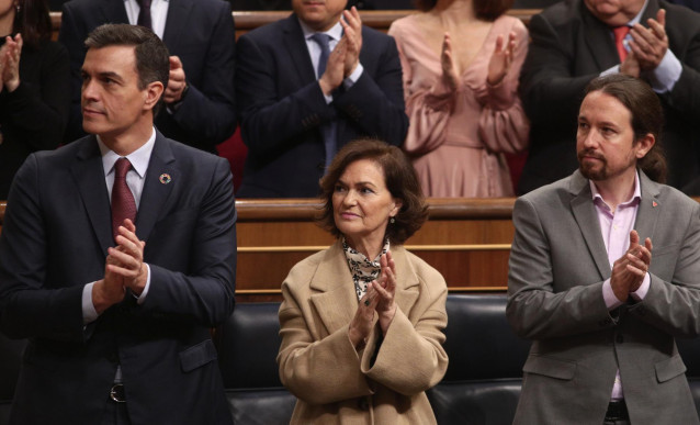 (I-D) El presidente del Gobierno, Pedro Sánchez; la vicepresidenta primera, Carmen Calvo; y el vicepresidente segundo y ministro de Derechos Sociales y Agenda 2030, Pablo Iglesias, aplauden en la Solemne Apertura de la XIV Legislatura