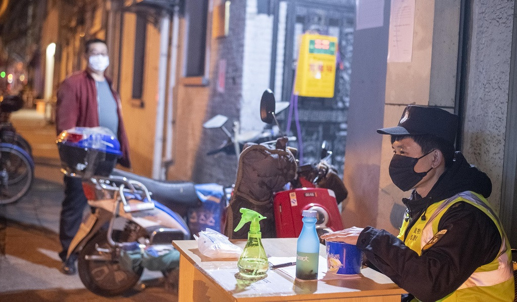 Un guardia de seguridad con mascarillas en una calle resiencial en China, control de coronavirus  Dave Tacon