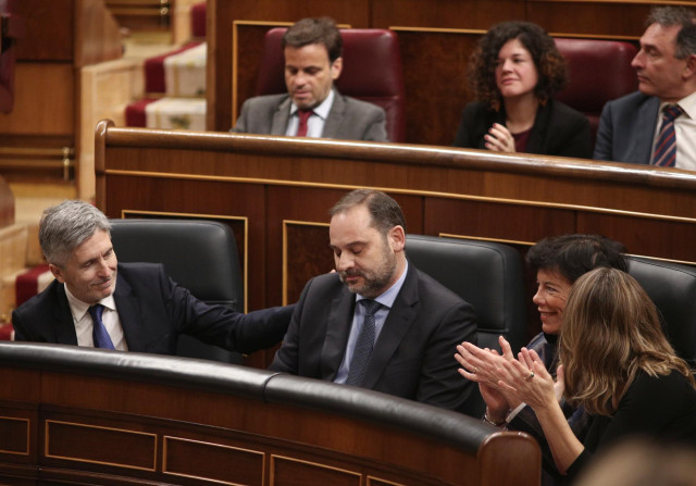 El ministro de Transporte, Movilidad y Agenda Urbana, José Luis Ábalos (centro), recibe una palmada en la espalda del minitro del Interior, Fernando Grande-Marlaska (izq), tras responder a las preguntas de la diputada del PP, Belén Hoyo y el portavoz adju