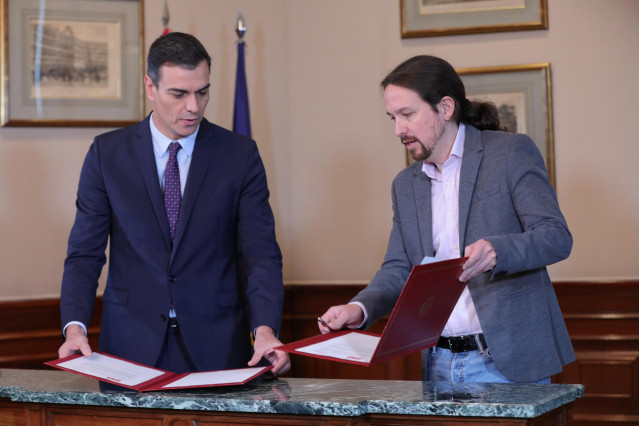 El presidente del Gobierno en funciones, Pedro Sánchez y el líder de Podemos, Pablo Iglesias, se estrechan la mano en el Congreso de los Diputados con el documento del principio de acuerdo para compartir un gobierno de coalición tras las elecciones genera