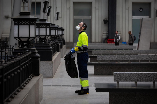 Un trabajador de la limpieza trabaja protegido con una mascarilla durante el segundo día laborable del estado de alarma por el coronavirus, en Barcelona (España), a 17 de marzo de 2020.