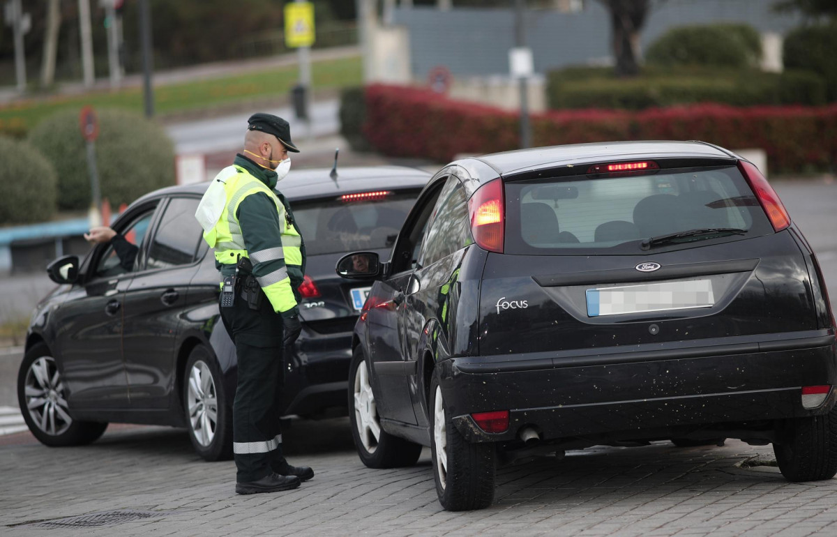 Un Guardia Civil de Tráfico para a un vehículo que se encuentra cerca de la entrada del recinto de Ifema