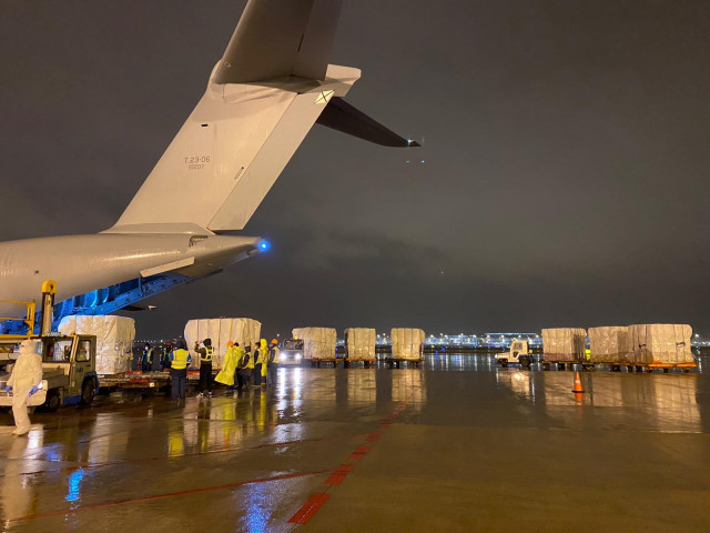 Varios trabajadores en Shangai cargan el avión del Ejército del Aire con material sanitario