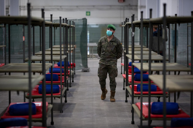 Un militar protegido con mascarilla pasea por el pabellón de la Fira de Barcelona habilitado para acoger a personas sin hogar en plena crisis del coronavirus.